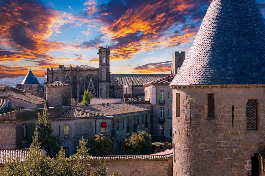 A historic town with a prominent church, a tower, and a distinctive conical building. 5