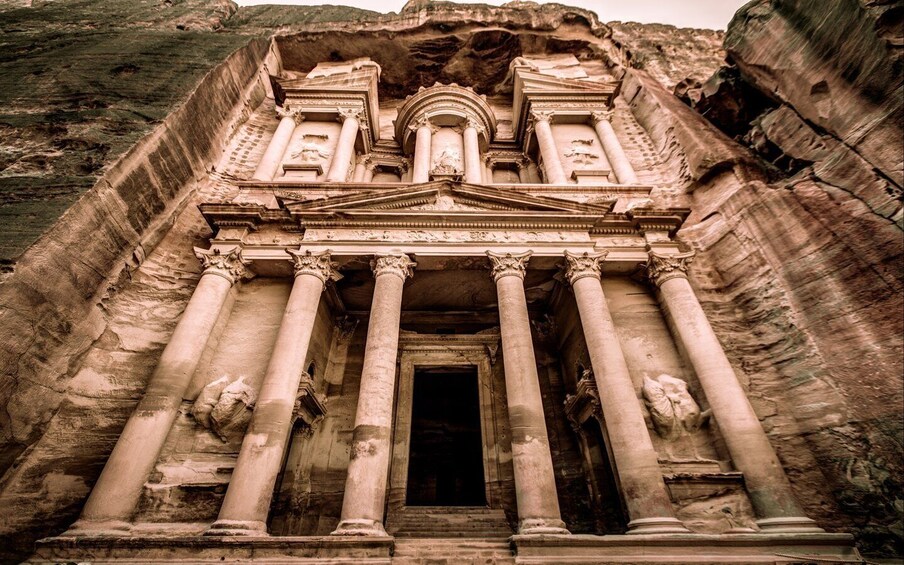 An ancient temple with large columns and a central doorway. 4