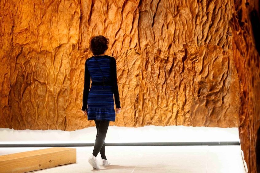 A person walking away from a textured wall. 2