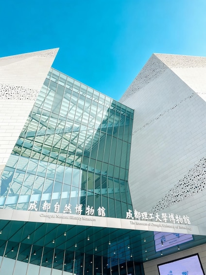 A modern building with reflective glass windows and a unique geometric design. 1