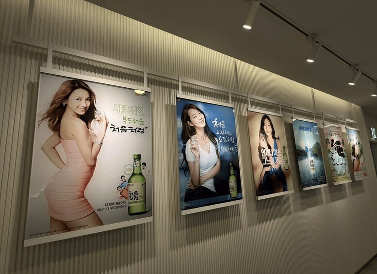 A series of posters on a wall, each featuring a woman and Korean text. 3