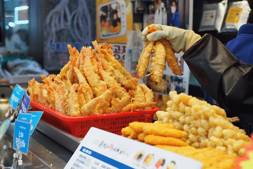A food stall with baskets of fried seafood and other items. 2