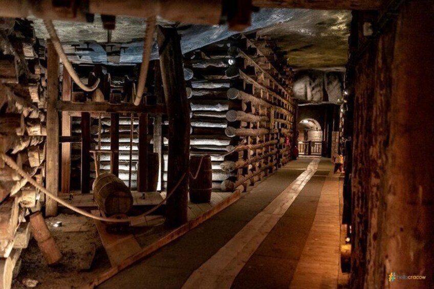 A dimly lit underground storage area with wooden shelves and barrels. 2