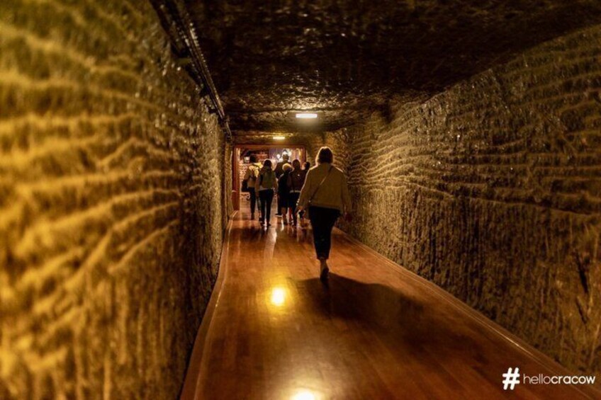 A tunnel with a wooden floor and stone walls. 4