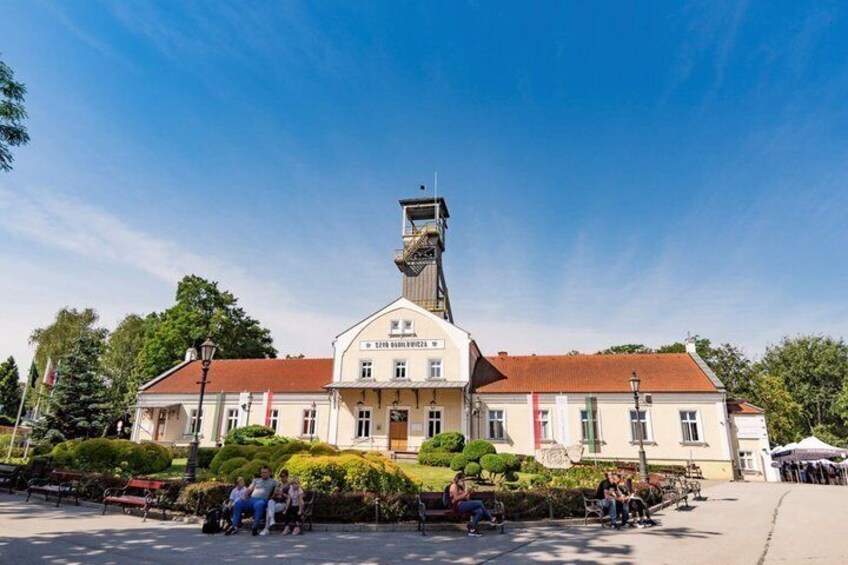 A historic building with a tower, surrounded by benches and people. 5