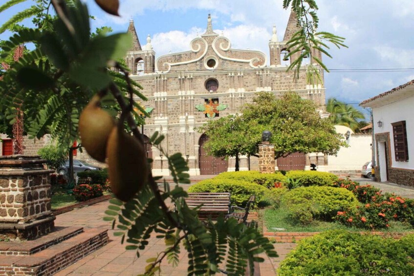 A historic church with a bell tower, surrounded by well-maintained gardens and a stone fountain. 4