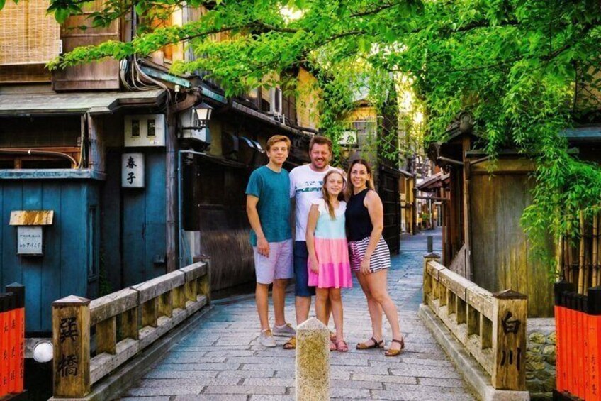 A narrow alley with traditional wooden houses, a stone pathway, and a wooden fence. 1