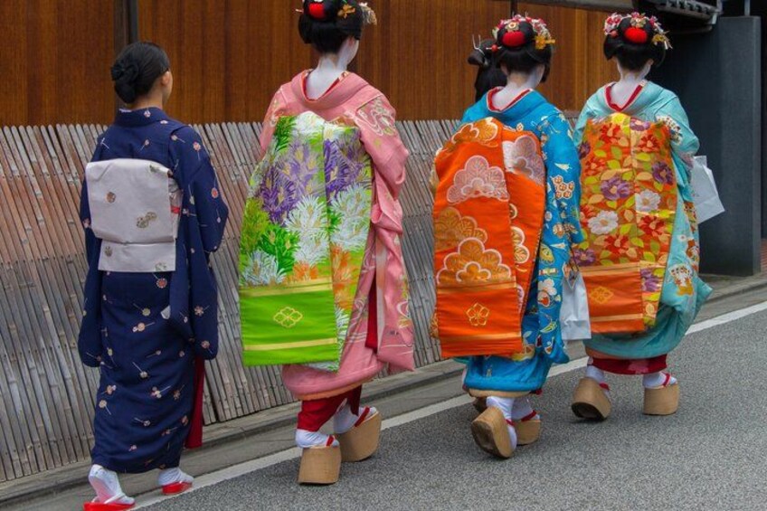 Three women in traditional Japanese kimonos walking on a street. 3