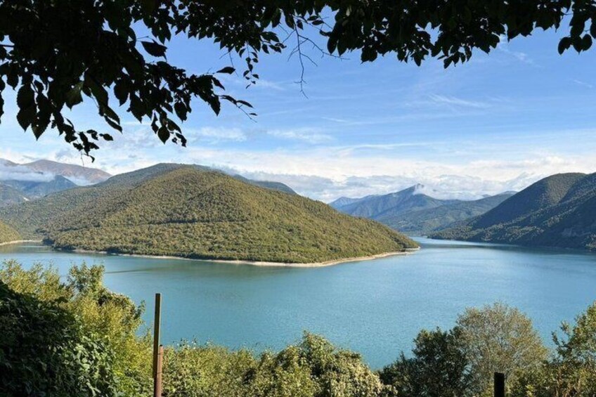 A lake surrounded by mountains and dense greenery. 2
