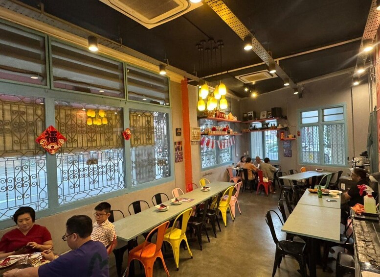 A restaurant with tables and chairs, decorative lights, and windows with metal grilles. 4