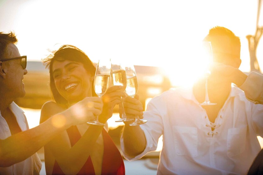 Three people toasting with champagne glasses at sunset. 5