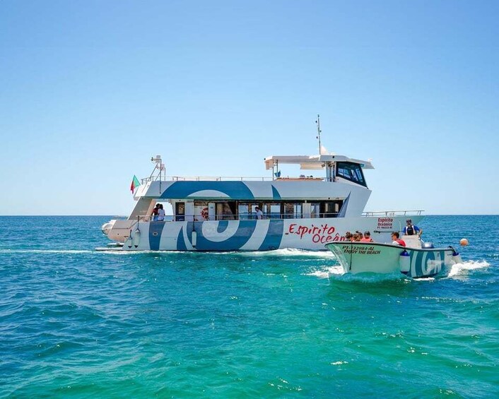 A large boat with 'Espiritito Ocean' written on its side, sailing on clear blue waters. 1