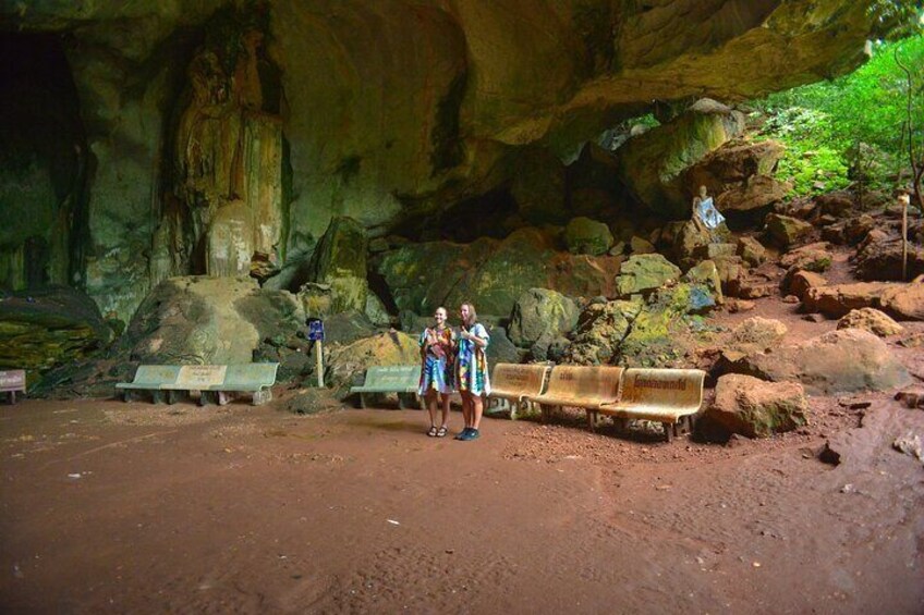 A cave with benches and a person standing in the foreground. 5