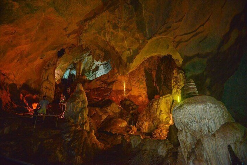 A cave with stalactites and stalagmites, illuminated by artificial lighting. 2