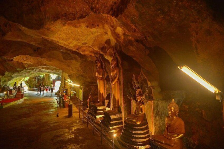 A cave with statues and a Buddha figure. 3