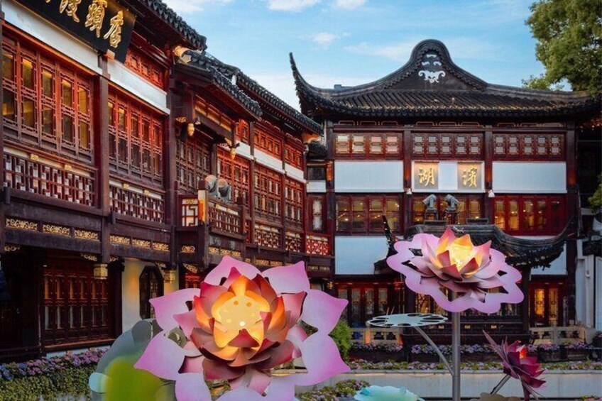 A traditional Chinese building with ornate architecture and large lotus sculptures in the foreground. 1