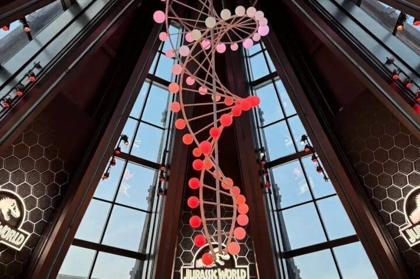 A large dinosaur-themed entrance with a prominent DNA helix sculpture. 2