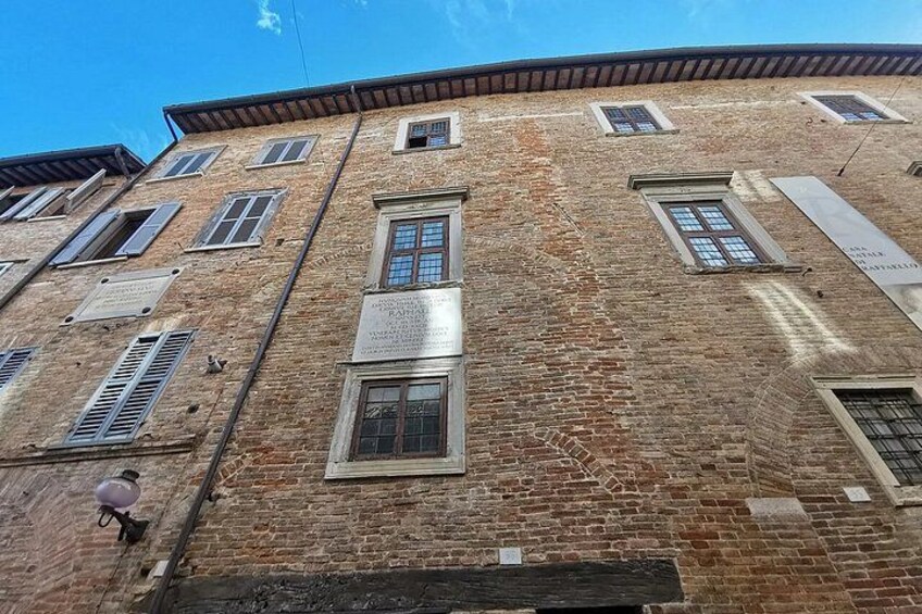 A multi-story brick building with several windows and a sign. 3