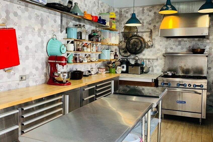 A kitchen with stainless steel appliances, wooden countertops, and a red mixer. 4