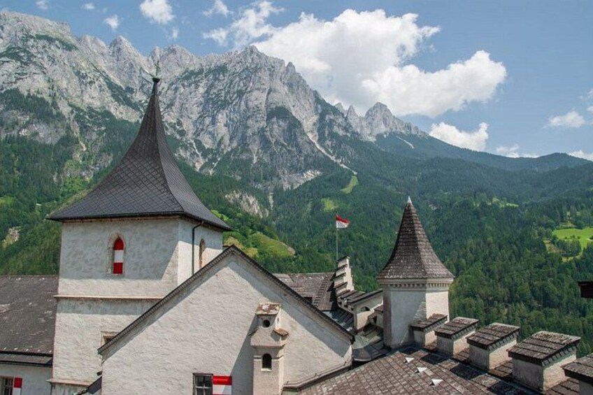 A mountain village with traditional buildings and a church, surrounded by lush green mountains. 2