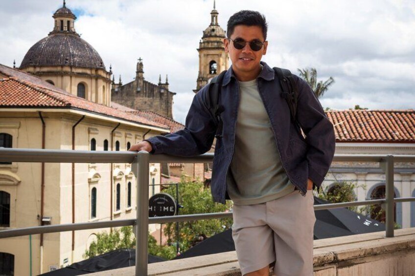 A person leaning on a railing with a historic building and a clock tower in the background. 4