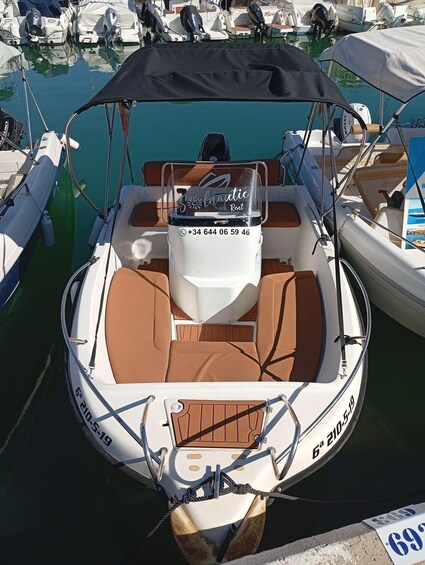 A boat with a canopy, registration number 6-210-5-19, docked at a marina with other boats. 3