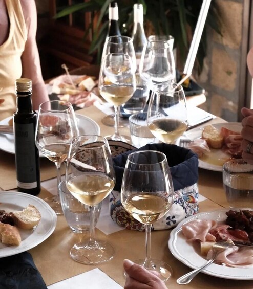 A table with wine glasses, plates of food, and a bottle of wine. 4