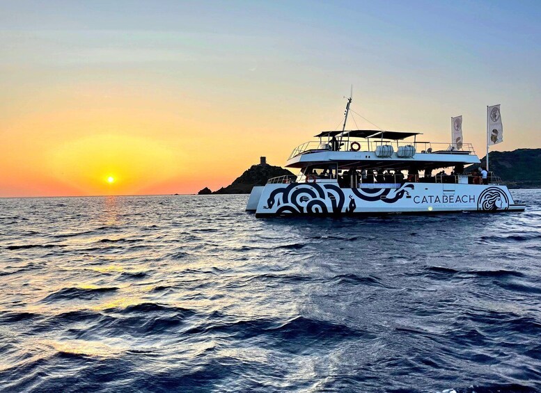 A boat named 'CATABEACH' with a sunset in the background. 1