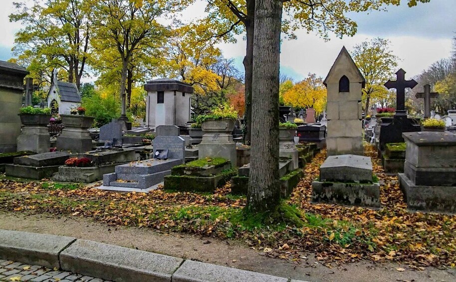 A cemetery with various gravestones and a prominent cross. 5