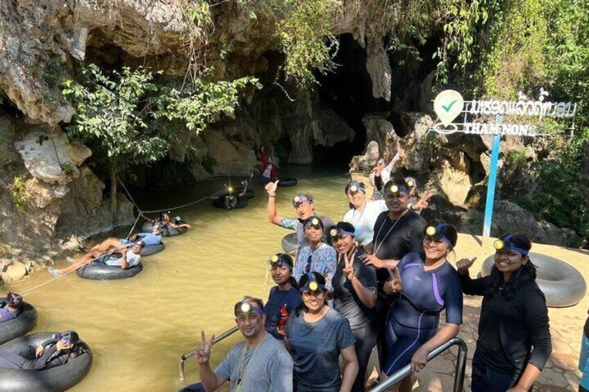 People in rubber tubes floating in a river, surrounded by rocky cliffs and greenery. 3