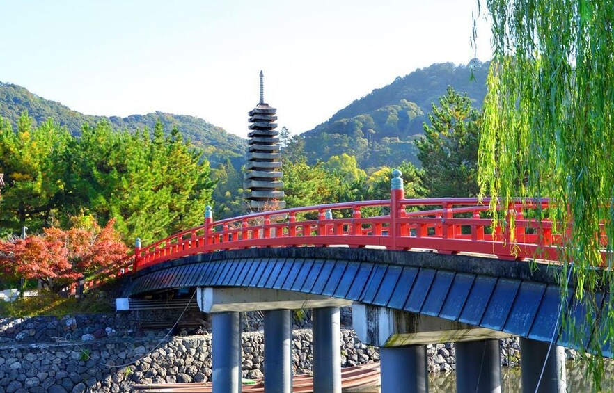 A red bridge with a pagoda in the background. 2