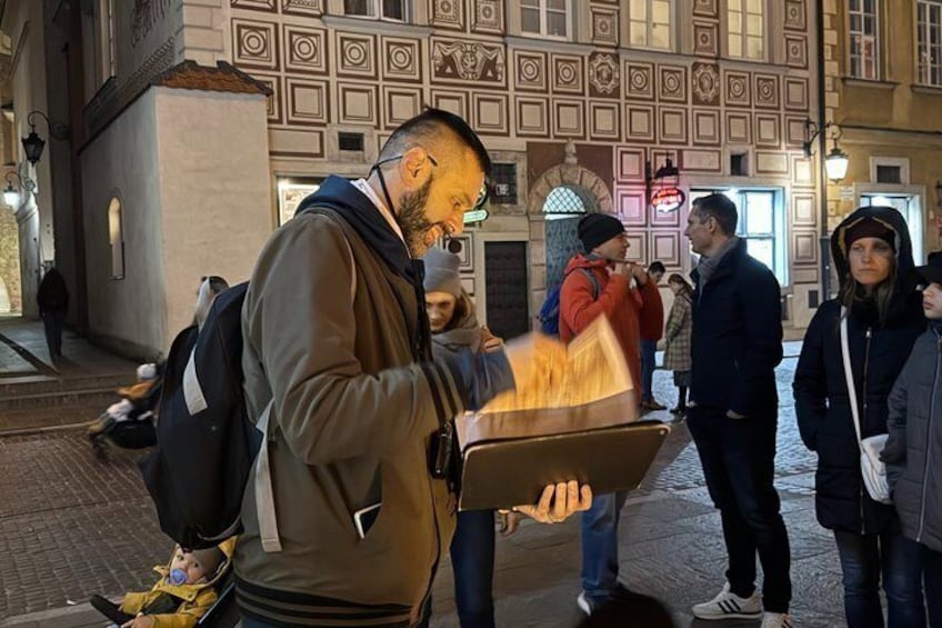 A man carrying a tray with food in a historic building with patterned walls. 4