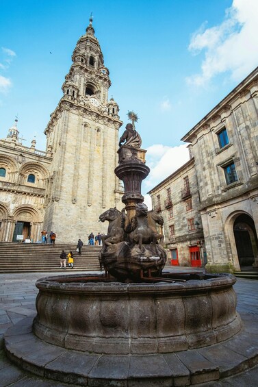 A historic plaza with a fountain, a large cathedral, and surrounding buildings. 2