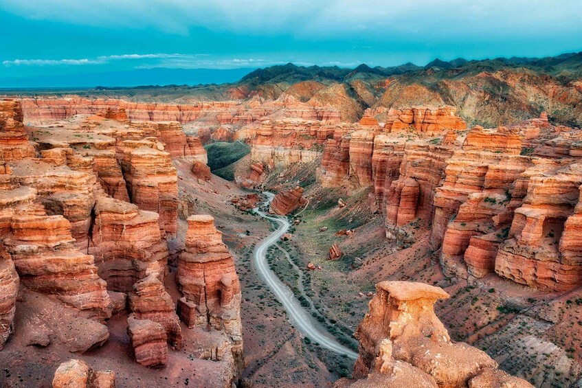 A canyon with layered rock formations and a winding road. 2
