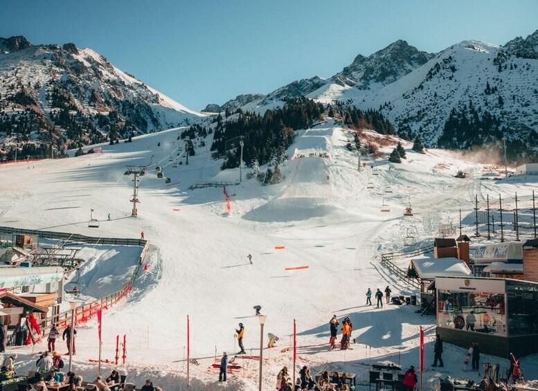A ski resort with a chairlift, ski slopes, and a mountain backdrop. 3