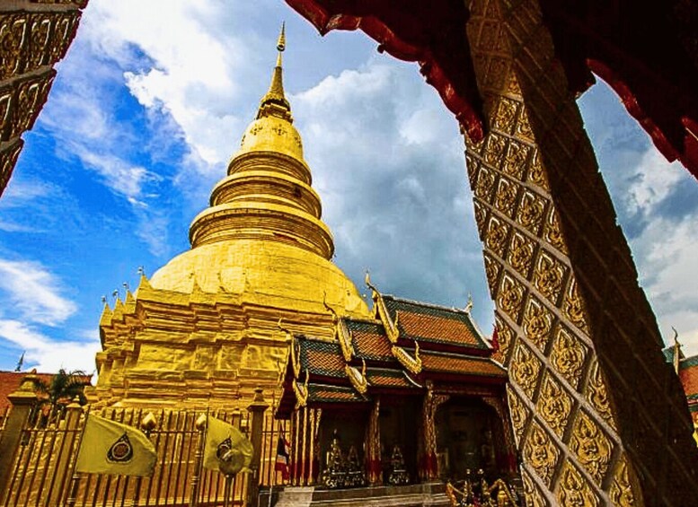 A golden stupa with intricate carvings, a traditional roof, and a clear blue sky. 5