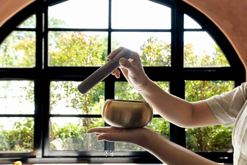 A person holding a bowl and a mallet, likely in a tea ceremony setting. 1