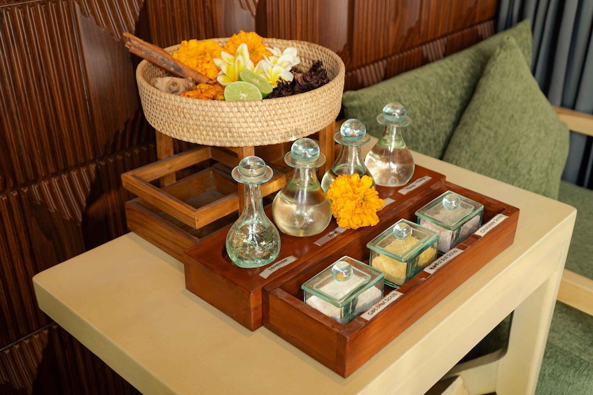 A wooden tray with glass containers and a woven basket of flowers. 5