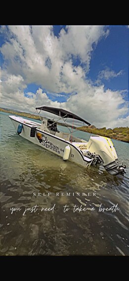 A boat named 'STRESS' on calm water with a partly cloudy sky. 5