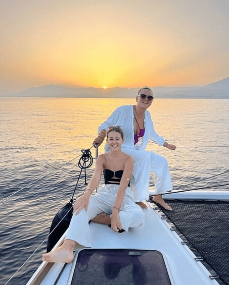 Two people on a boat with a sunset in the background. 3