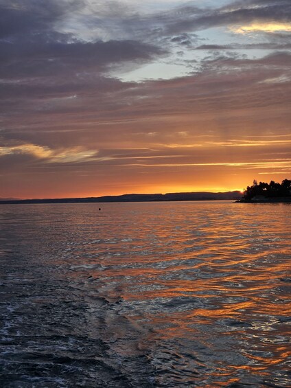 A sunset over a body of water with a distant shoreline. 5