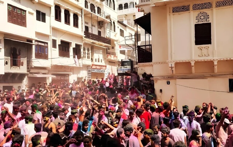 A crowded street scene with people gathered, possibly for a festival or celebration. 4