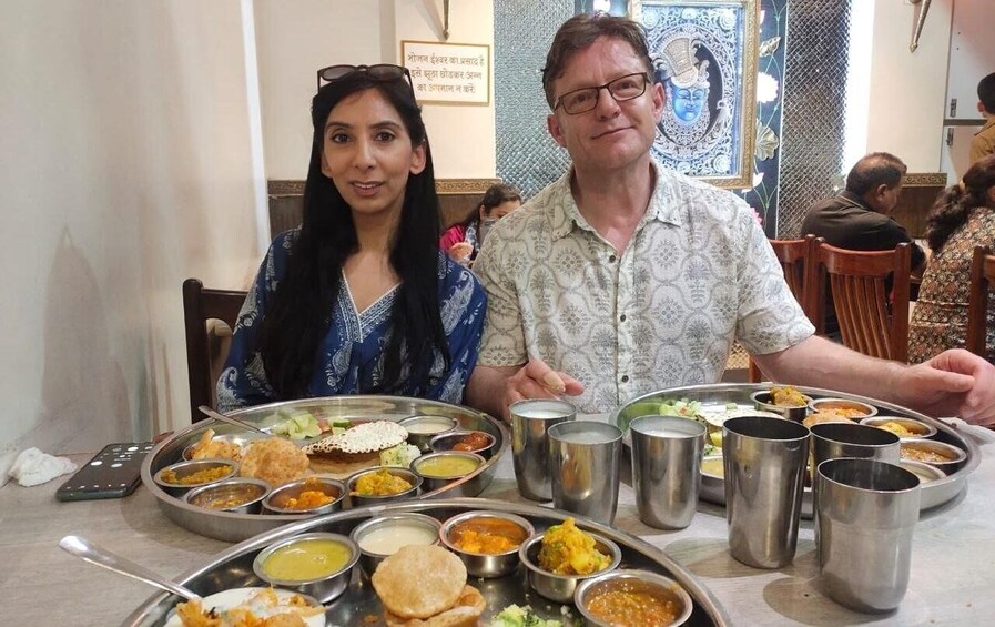A dining table with various dishes and metal cups, likely in a restaurant. 5