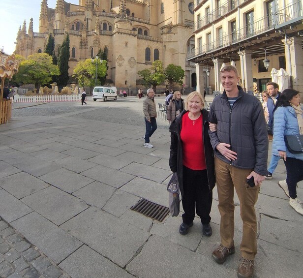 A historic cathedral with intricate architecture, a paved square, and people walking. 4