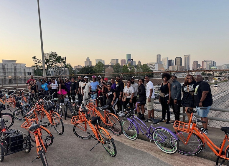 A group of people standing on a bridge with bicycles parked in front of them. 2