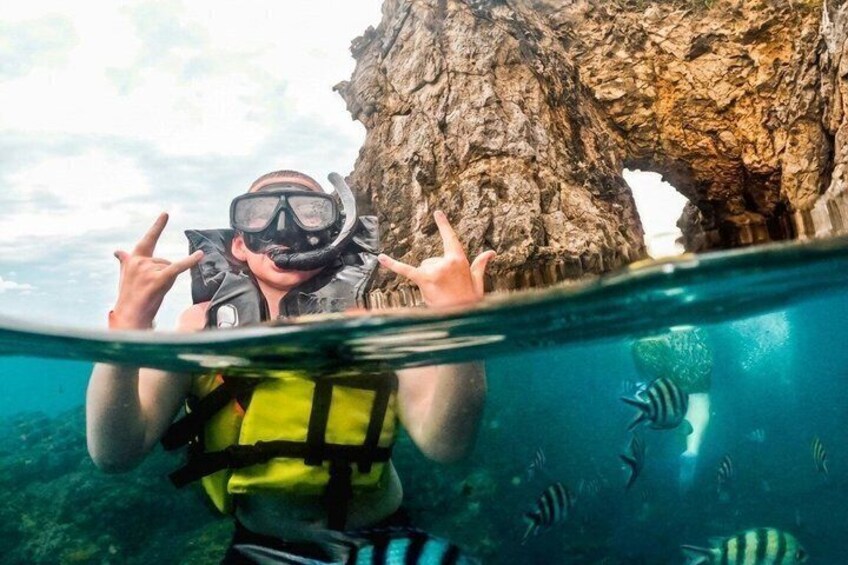 A diver underwater near a rocky formation with marine life. 1