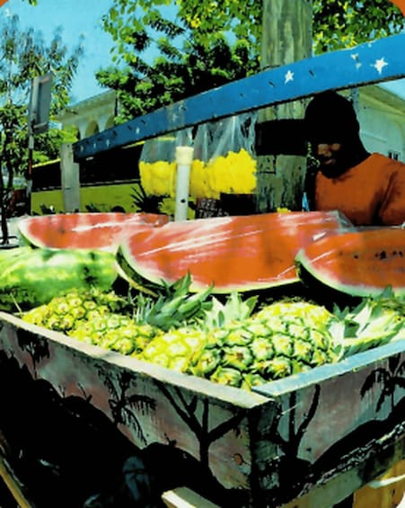 A fruit stand with watermelons and pineapples. 2