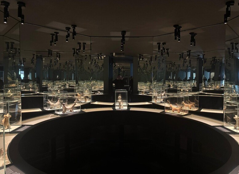 A museum with glass display cases containing various artifacts. 2