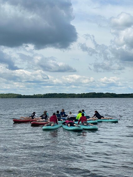 People on paddleboards in a lake with a cloudy sky. 2