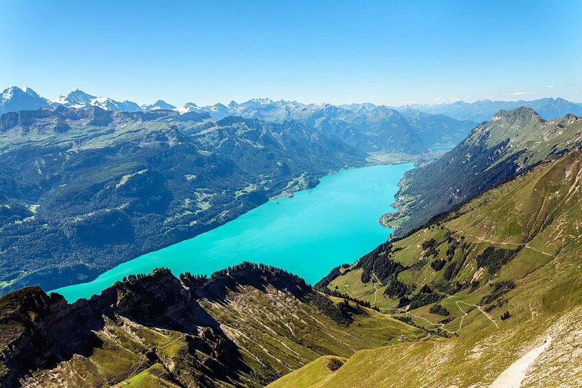 A turquoise lake surrounded by rugged mountains and green valleys. 4